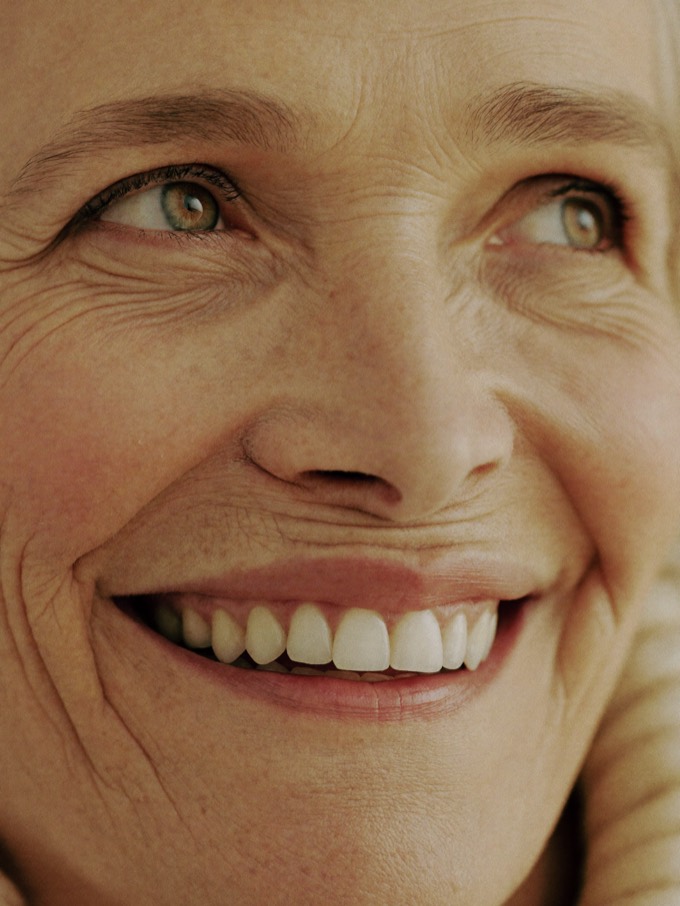 An older woman smiling warmly, her bright even teeth framed by gentle laugh lines